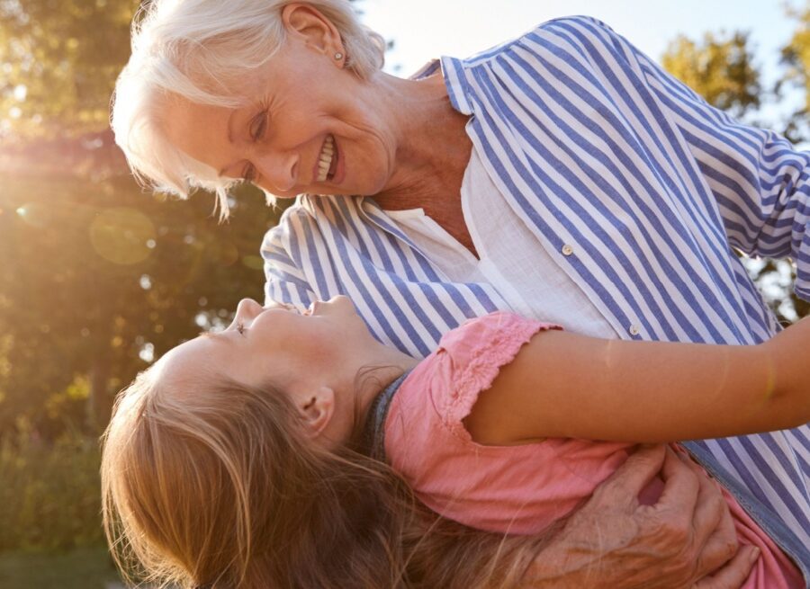 A grandmother playing with her granddaughter outside.