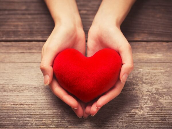 Close-up of hands holding a red heart