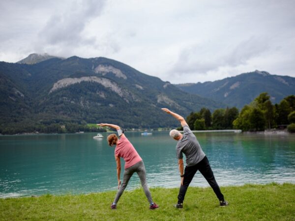 Couple doing tai chi by a lake
