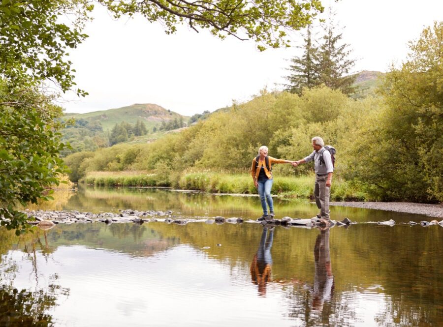 A couple walking across stepping stones.