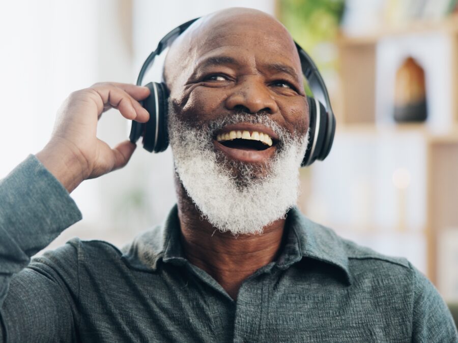 Smiling man listening to music through headphones