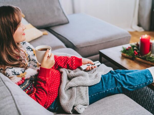 A woman relaxing wearing a Christmas jumper.