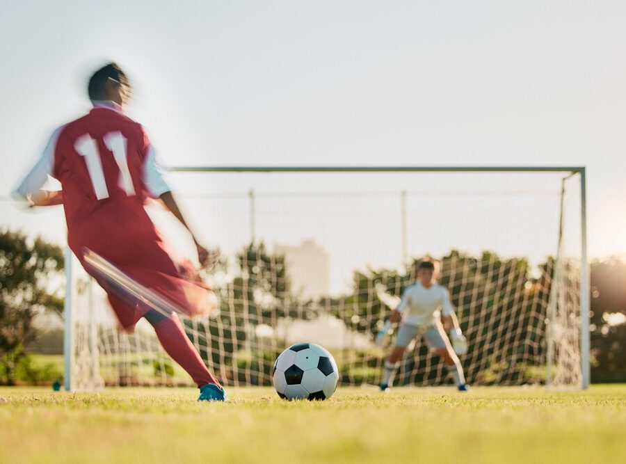 A footballer taking a shot at a goal.
