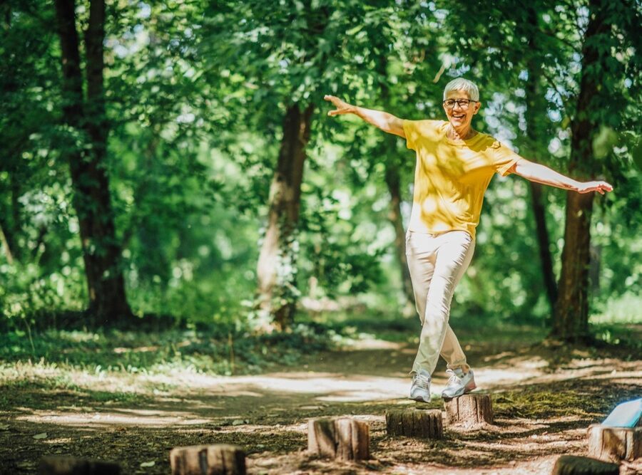 A woman doing balancing exercises outdoors.
