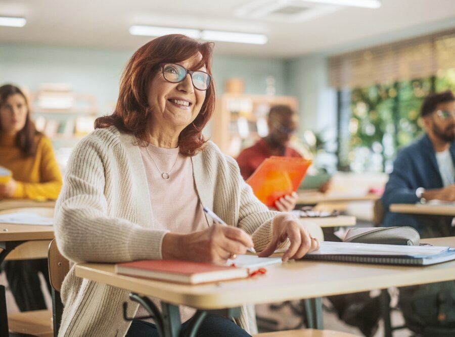 Happy senior woman taking notes in a classroom