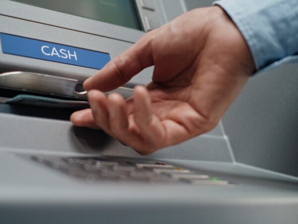 A person using an ATM to withdraw cash.