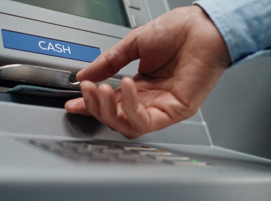 A person using an ATM to withdraw cash.