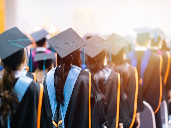 University students graduating wearing caps and gowns.