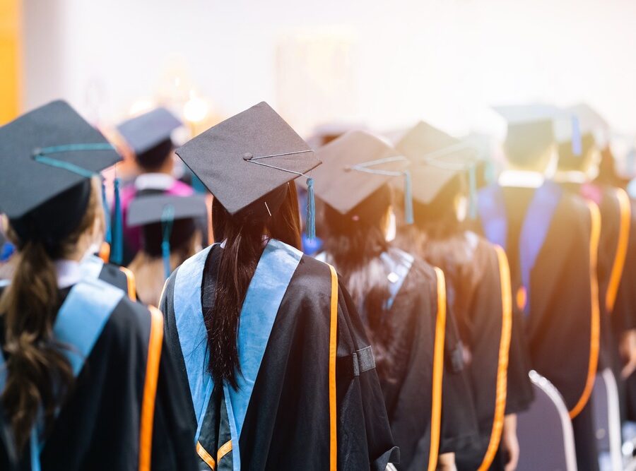 University students graduating wearing caps and gowns.