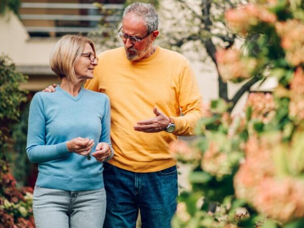 Mature couple walking outside a house