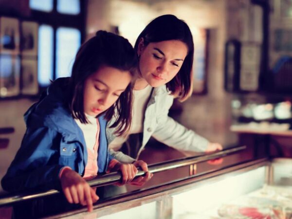 A mother and daughter viewing a museum exhibit.