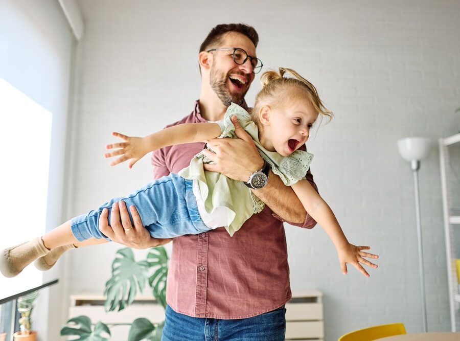 A father playing with his young daughter.