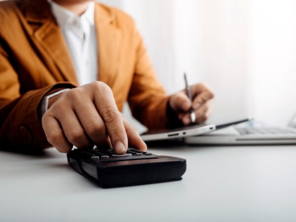 A business owner using a calculator at a desk.