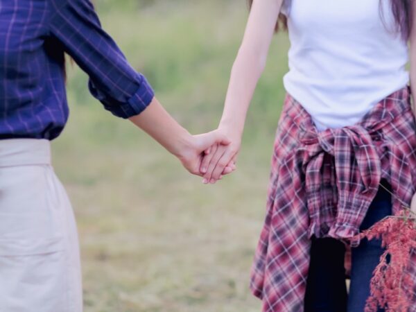 Two women holding hands.