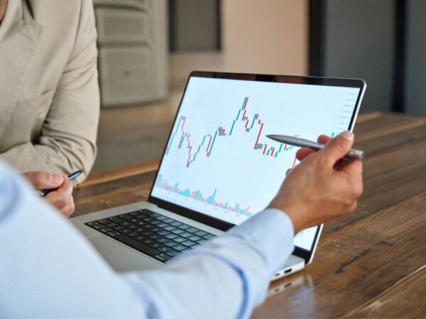 A man reviewing stock market movements on a laptop.
