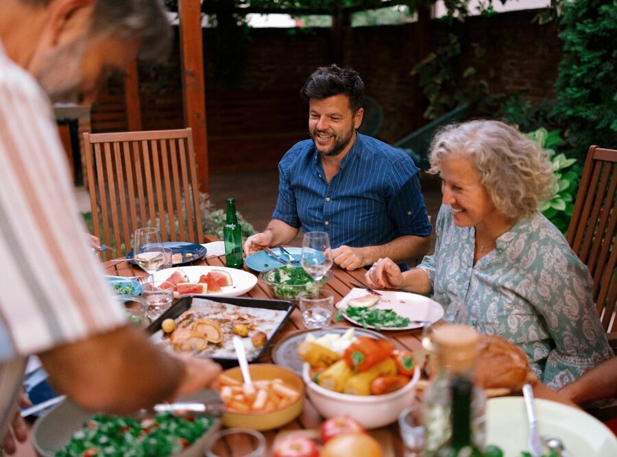 A multigenerational family eating together outdoors.