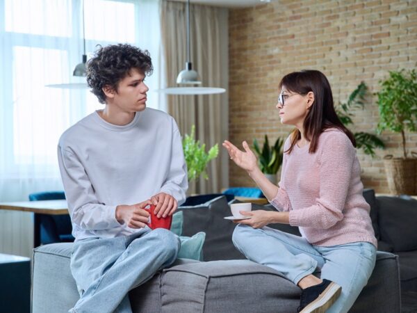 Middle-aged mother talking to her 18-year-old son at home